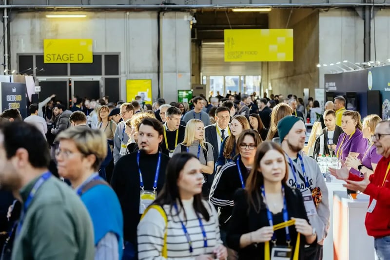Busy exhibition stand at the E-Commerce Berlin Expo 2026 with numerous visitors networking and engaging in conversation